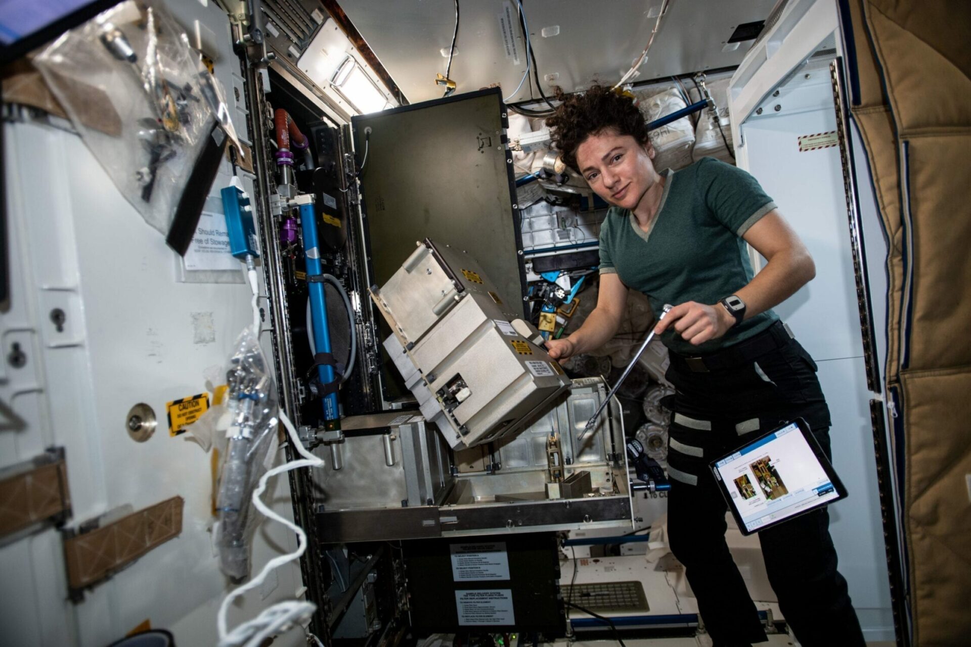 NASA astronaut Jessica Meir performs in-flight maintenance on the Major Constituent Analyzer Mass Spectrometer the International Space Station.